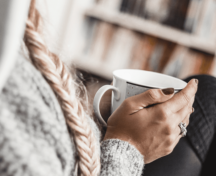 woman with braid holding mug in hand | Ductless Heating for a Cozy Indianapolis Winter | Homesense HVAC Indiana