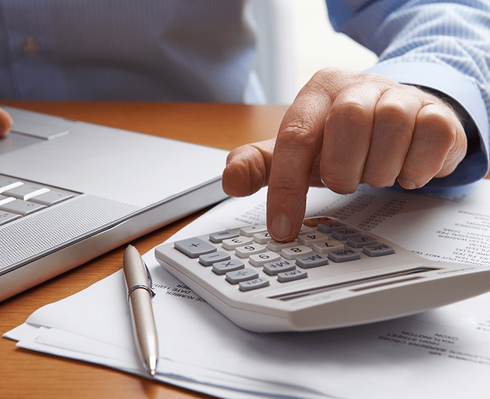 Man with calculator laptop | How Does Furnace Service Prevent Breakdowns | Homesense Indianapolis